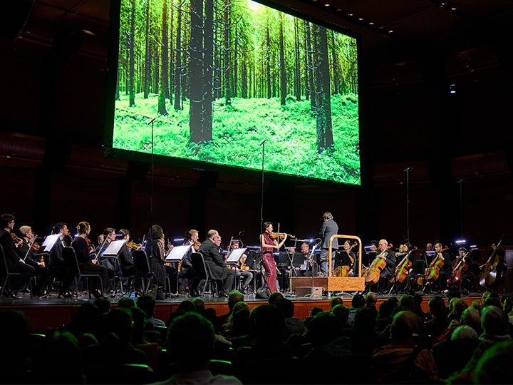 Nancy Zhou performing with Xian Zhang and the New Jersey Symphony with a projecter playing above